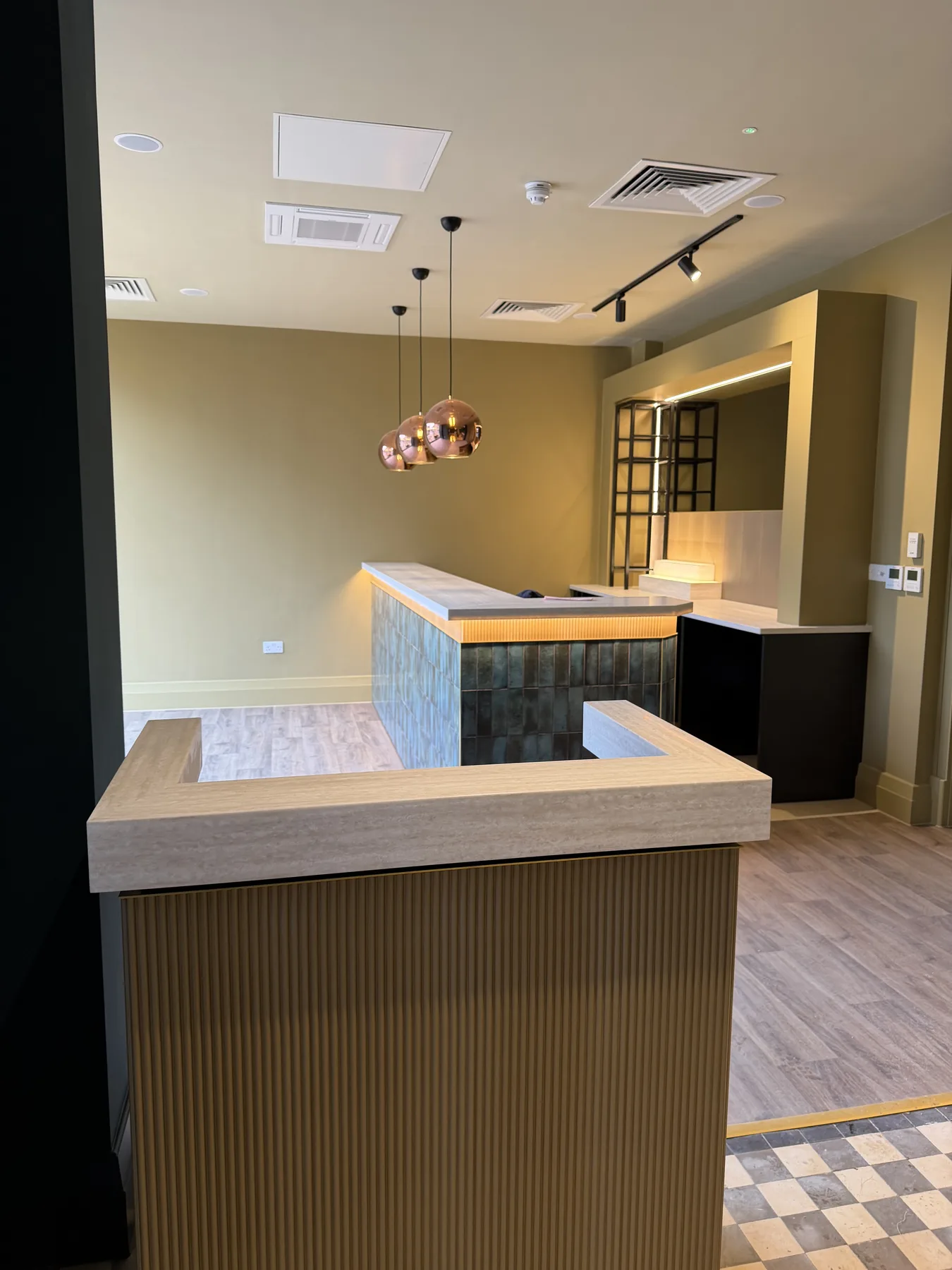Stone-topped bar and back bar under copper pendants