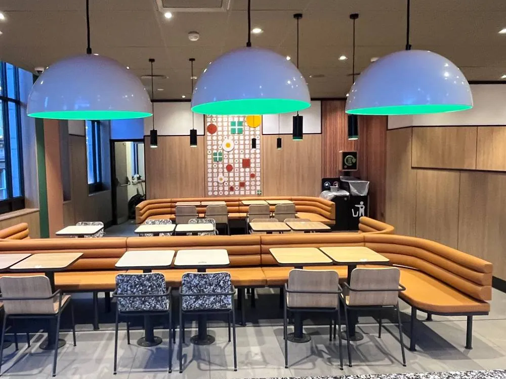 Feature pendants over banquette seating in a reimaged fast serve restaurant
