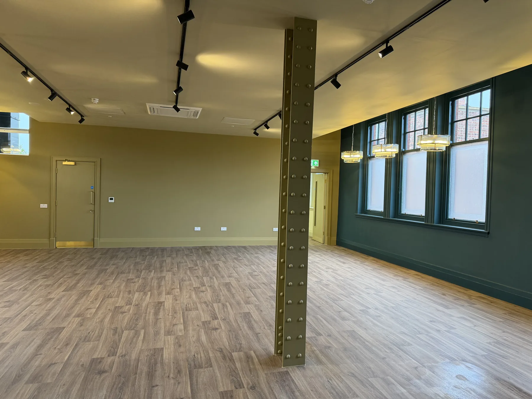 Restaurant dining room at Blakey Moor, Blackburn, with a riveted steel column, dark walls and track lighting