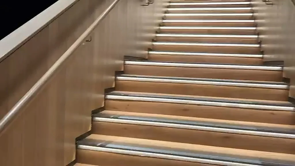 Oak-clad staircase from the landing, with lit nosings and oak handrails