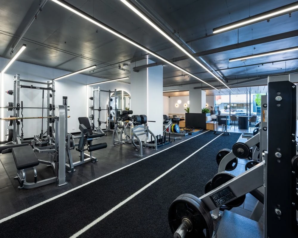 Gym free weights area with arched mirror feature wall